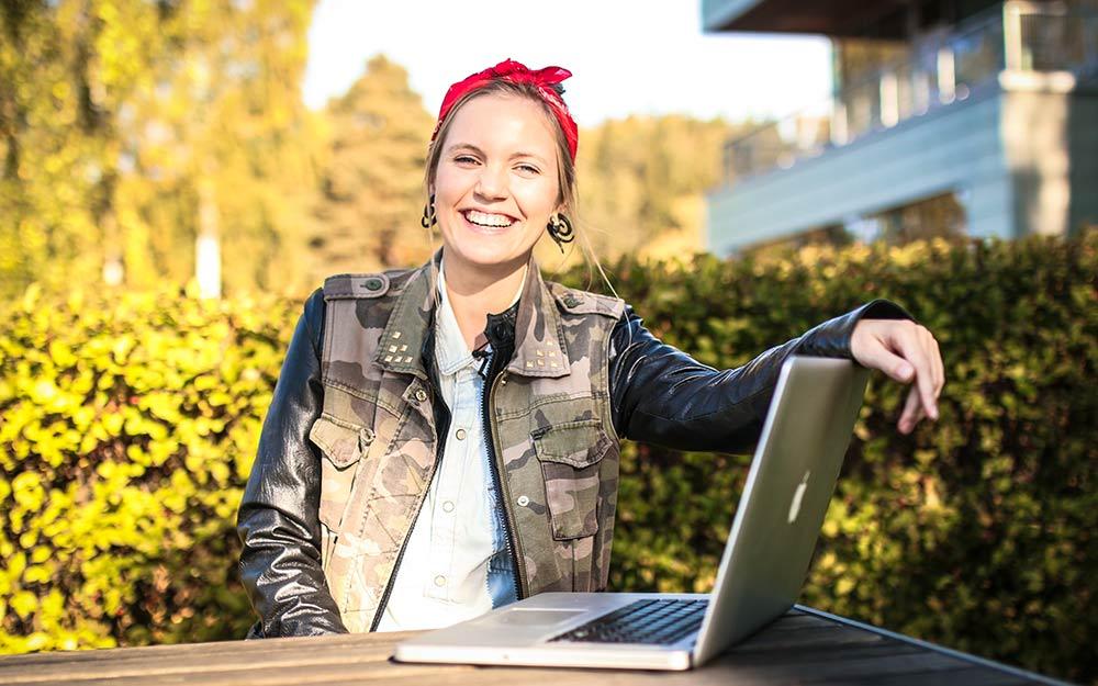 Girl smiling and holding a laptop