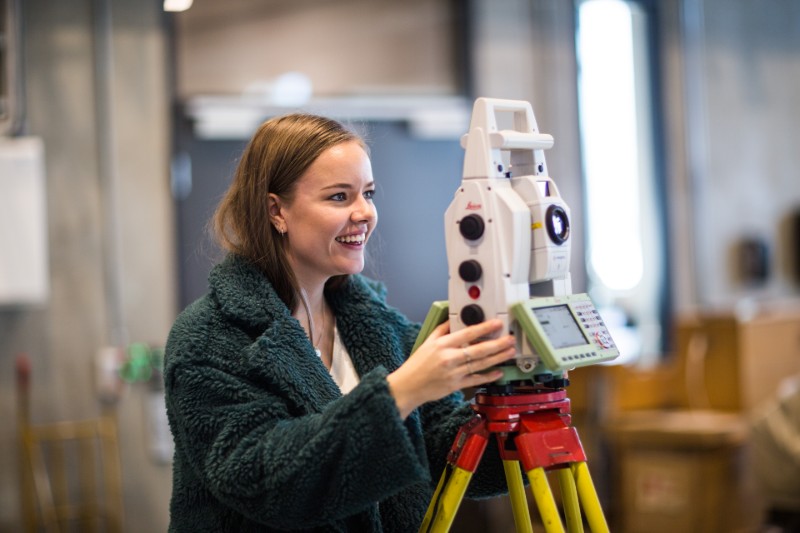 Picture of student with land surveing equipment