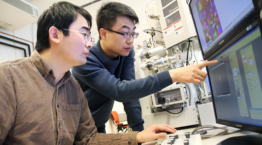 Postdoc Kai Zhang and PhD candidate Hailong Jia are investigating the extrusion microstructure by electron back-scattered diffraction (EBSD). Photo: Per Henning/NTNU
