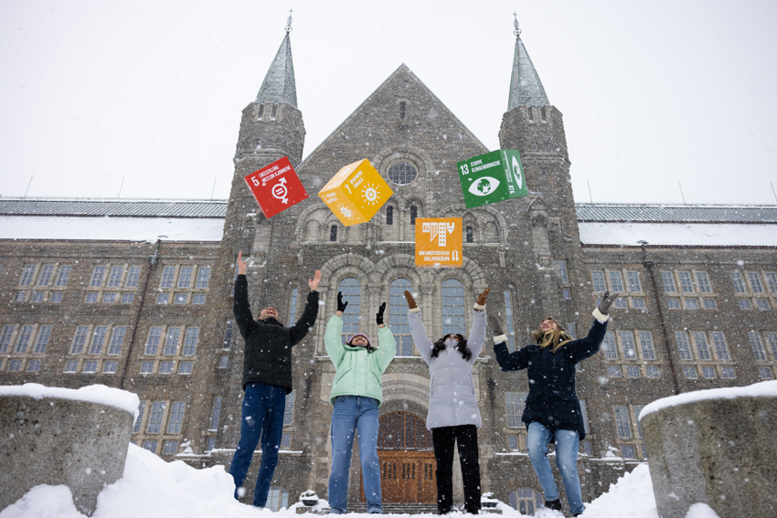 Picture of 4 students outside the main building at Gløshaugen