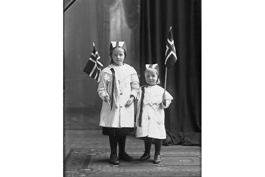 Two little girls in white dresses, Norwegian flags