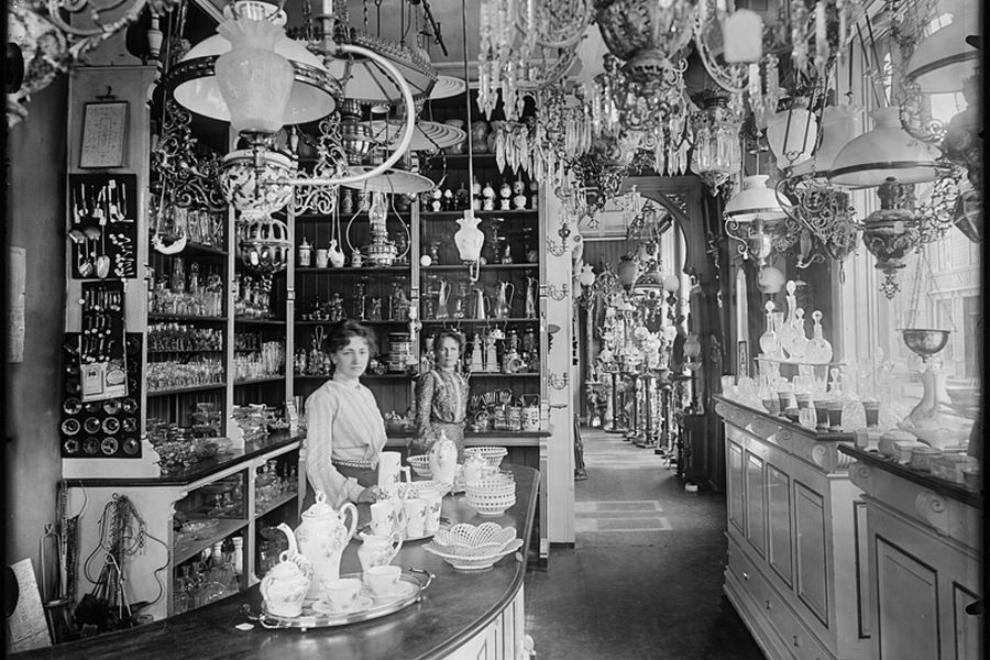 Interior and employees in a shop selling products of glass and china, lamps and mirrors, 1902