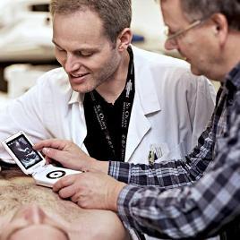 Photo of Ole Christian Mjølstad and Hans Torp using a handheld ultrasound apparatus.