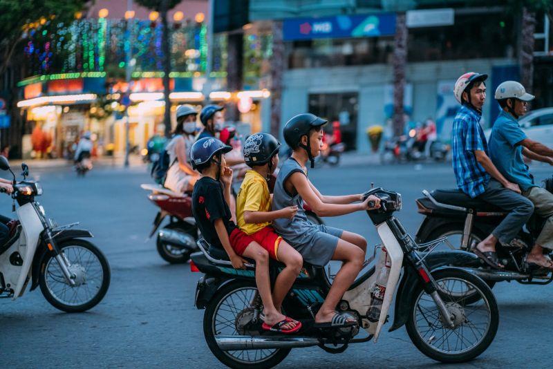 Three children on a scooter. Photo