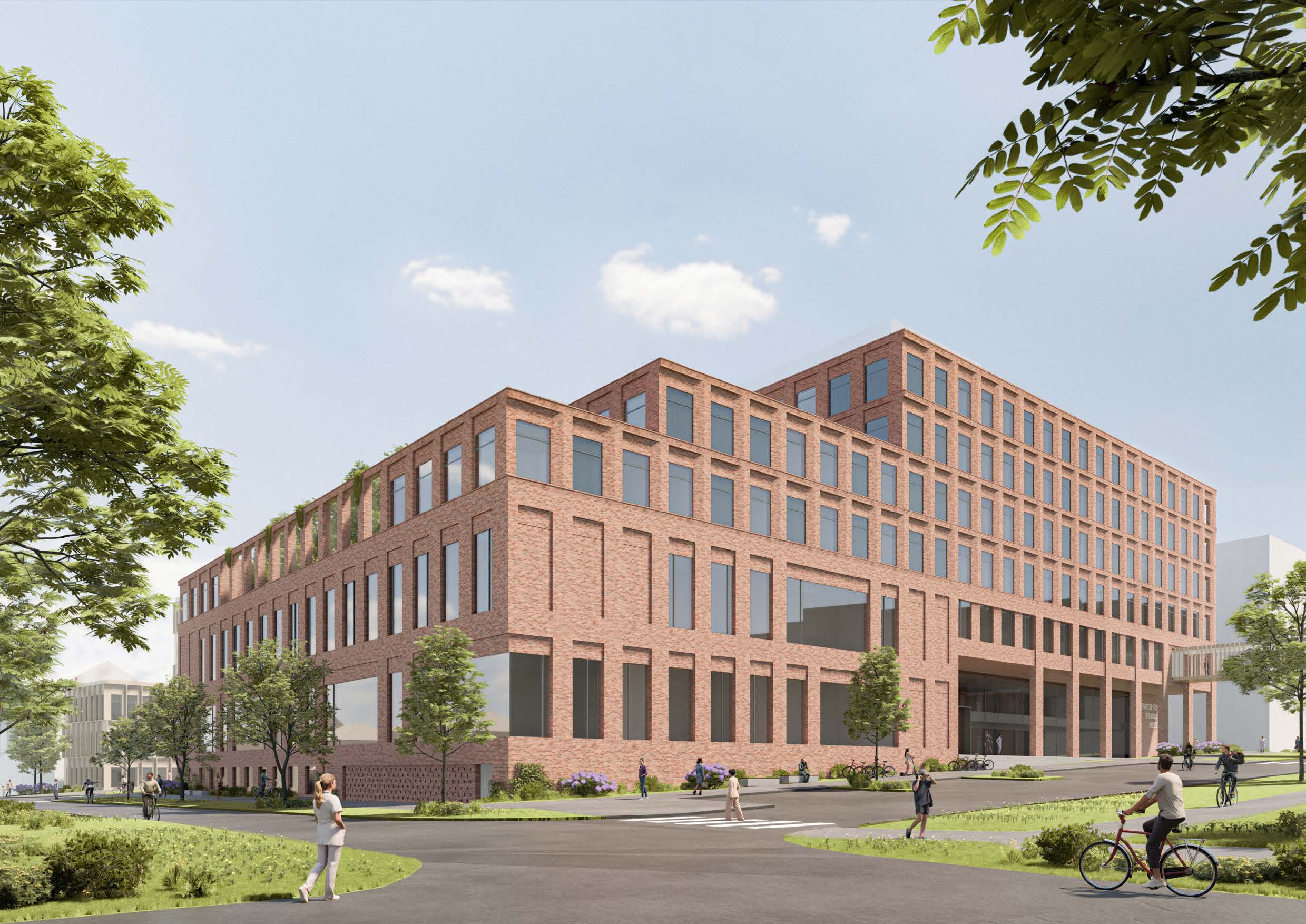 Modern brick building with large windows and greenery on the roof, surrounded by trees, grass, and walkways