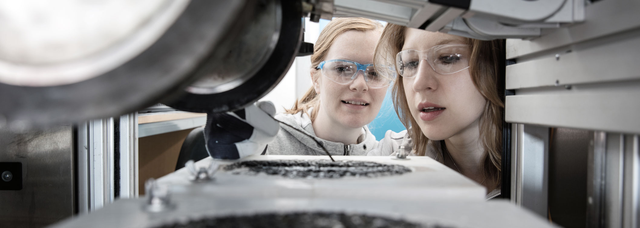 Photo. Two researchers testing asphalt in lab.