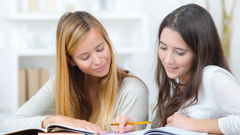 Two students are reading a book. Foto: Colourbox
