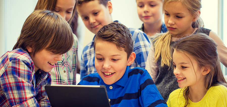 A group of children and a ipad. Photo