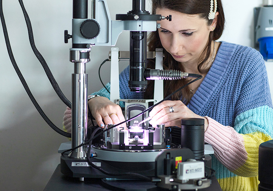 Researcher working with a sample in a microscope in the Functional topological systems lab. Photo