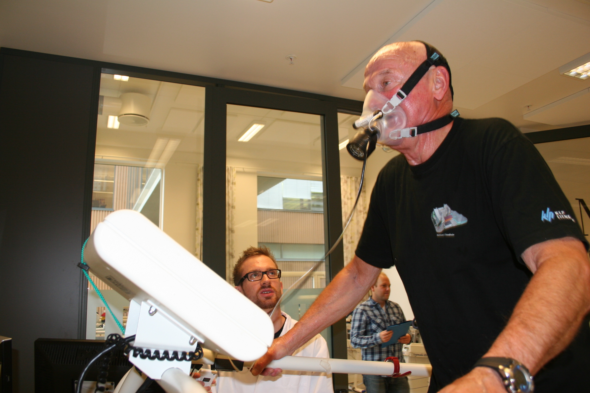 A man with an oxygen-mask running on a treadmill