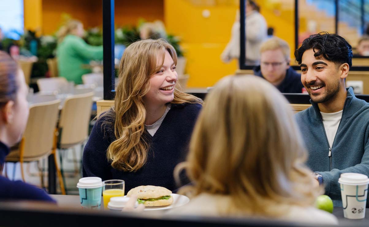 Students smiling around a table