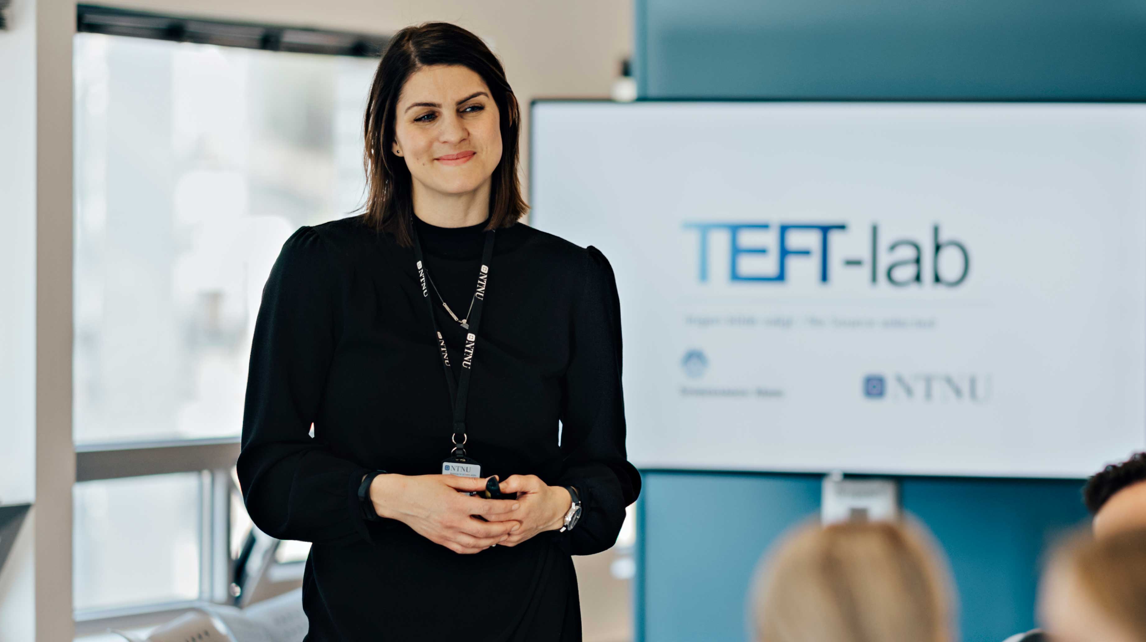 Woman standing in front of screen that says TEFT-lab