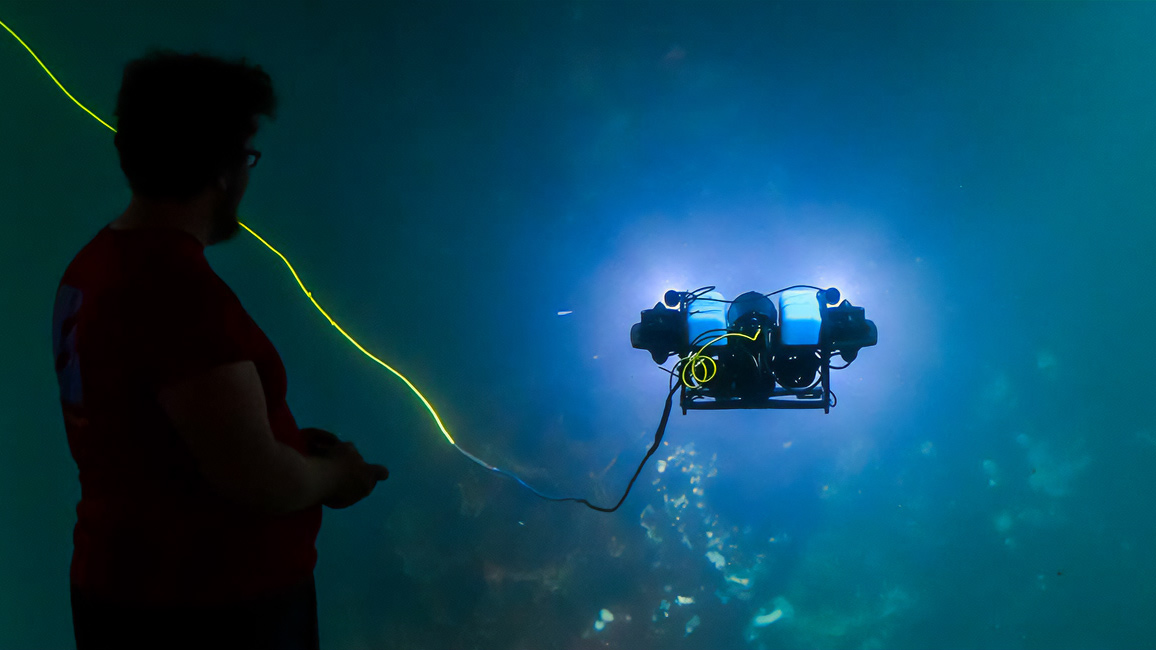 Man looking at an underwater robot
