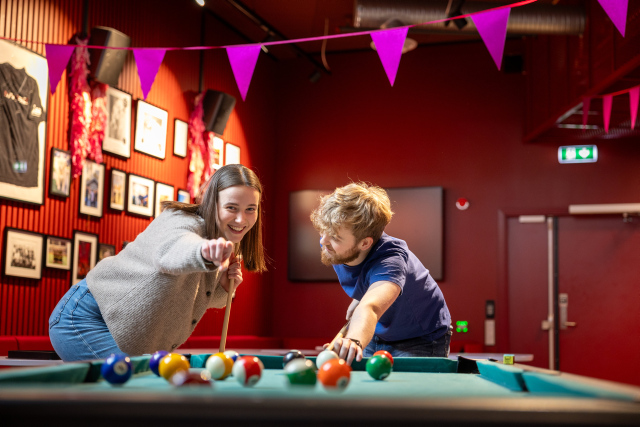 Two students playing pool