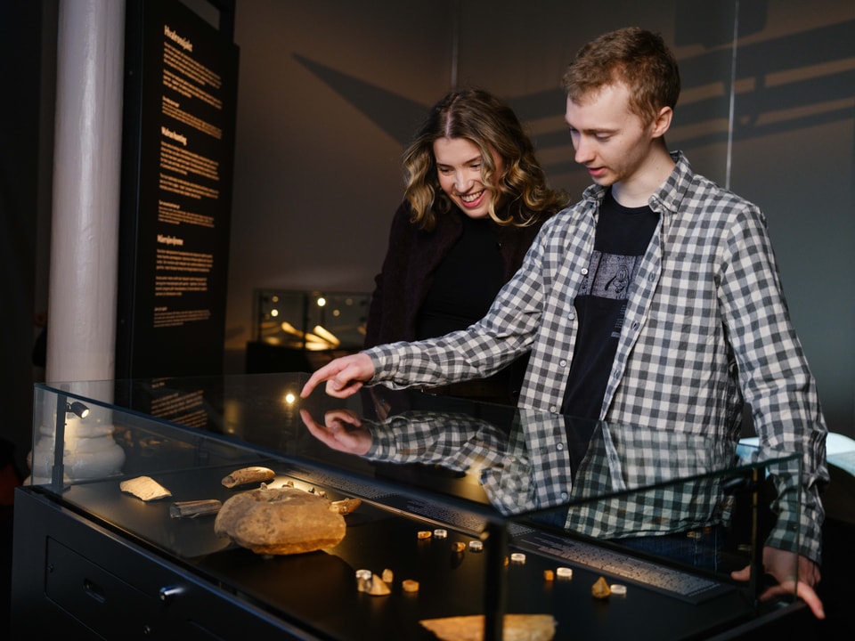 Man and woman looking at objects in a glass case