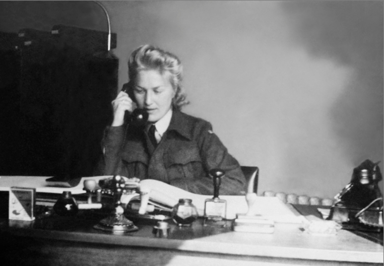 Liv Grannes sitting at her desk talking on the telephone. Photo
