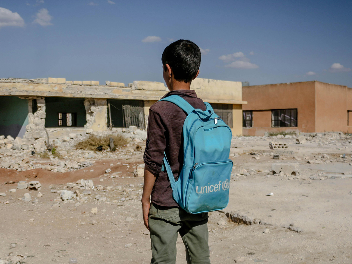 Boy looking at ruined building. Photo