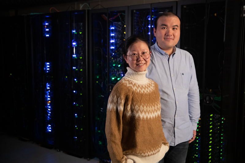 Two researchers infront of computer cabinets