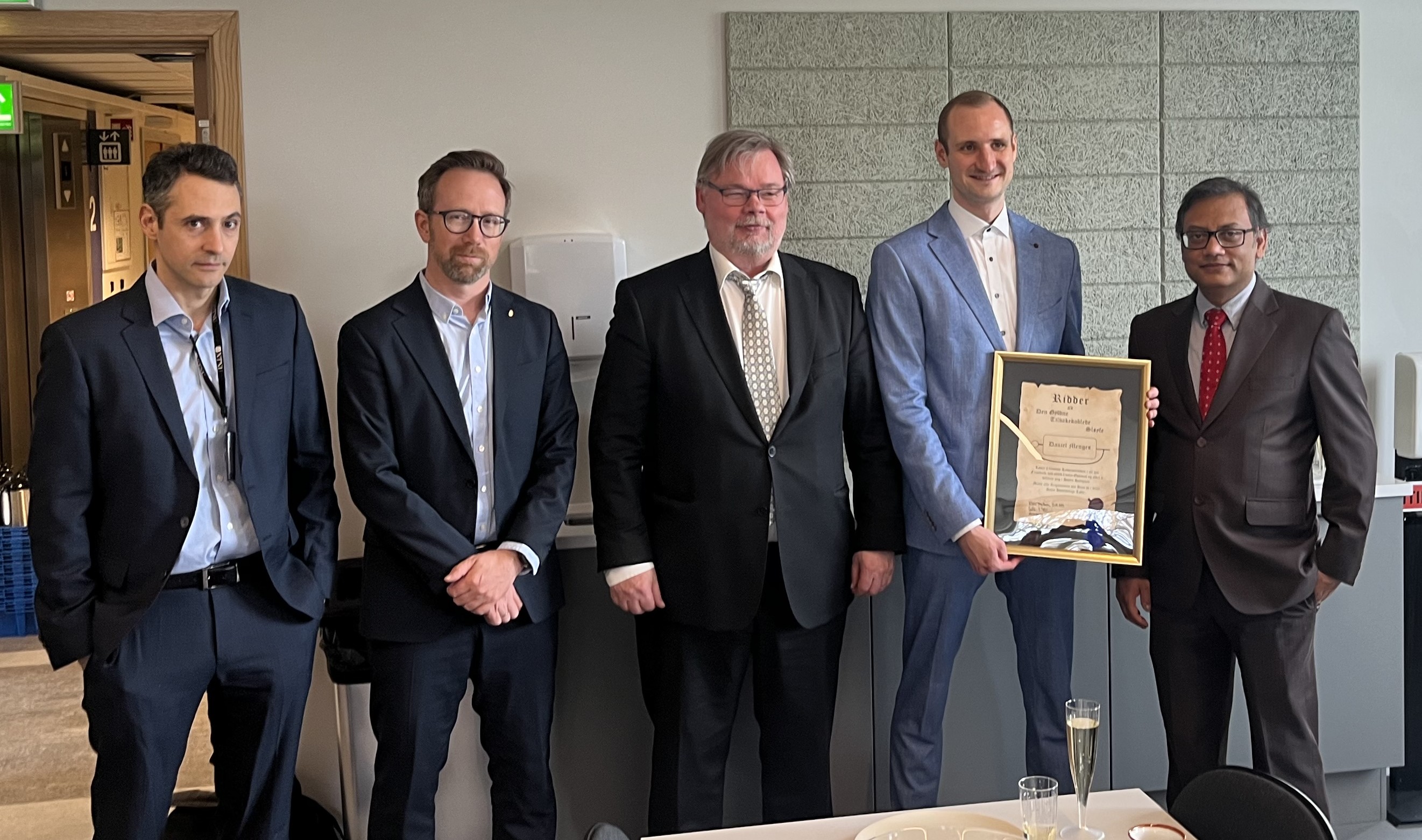 Photo of the PhD candidate with his superviser to the right and 3 of his assessment committee to the left.