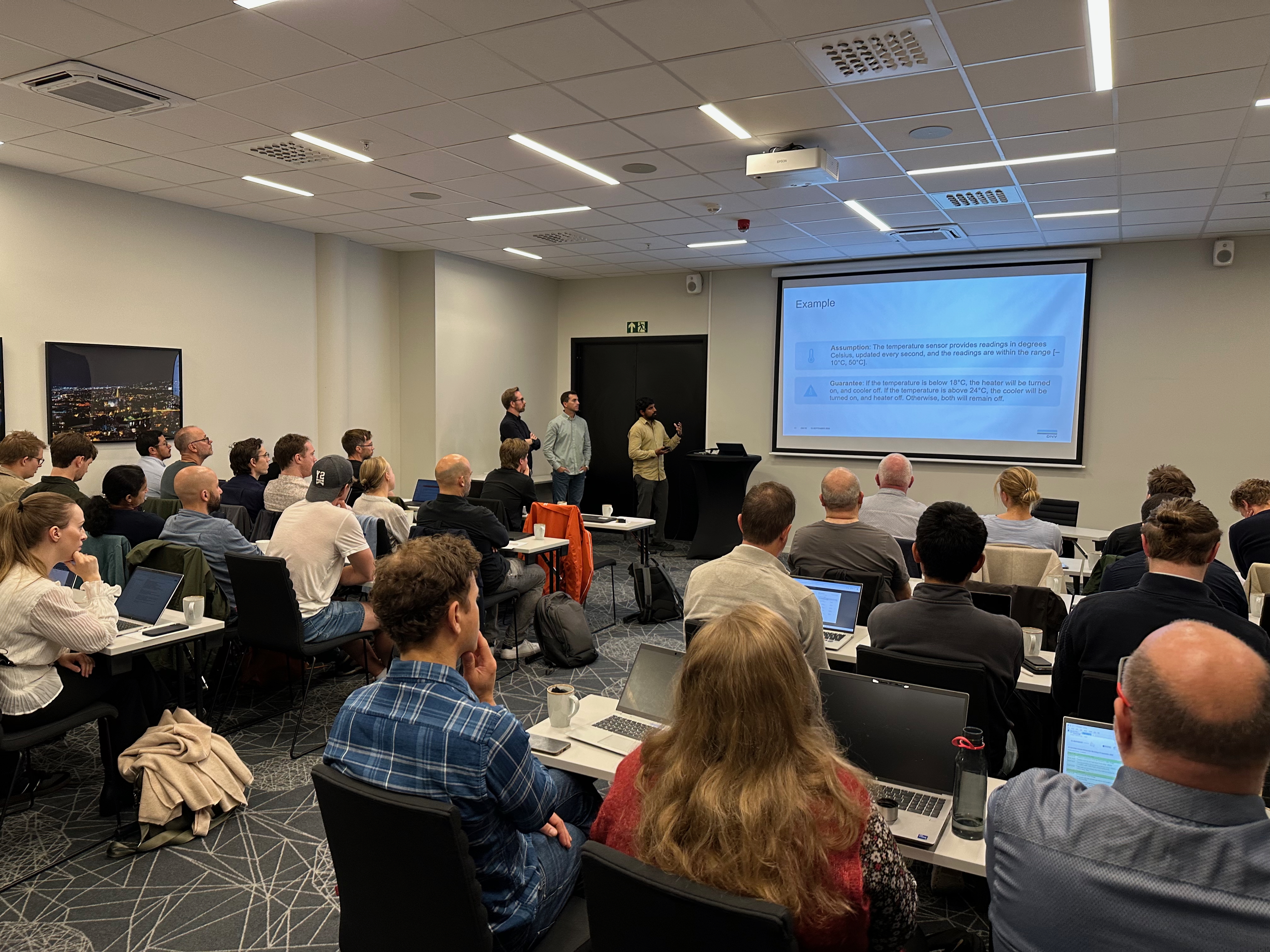 Photo of the audience and three presenters from DNV. 