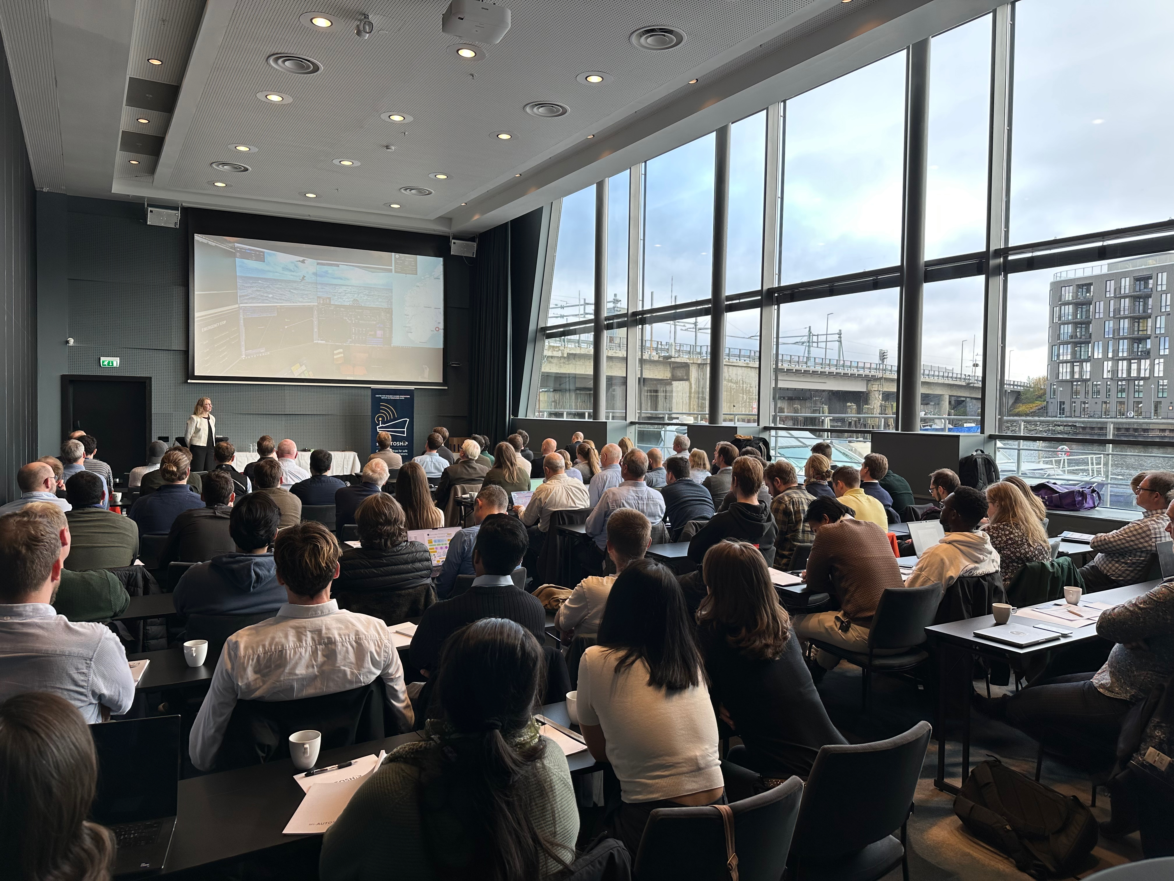 One presenter presenting to a large audience. 