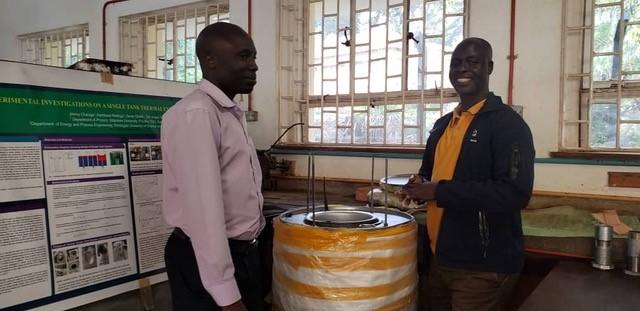 Dr. Karidewa , a Supervisor of  Jimmy Chaciga at makerere University discussing about the 100L of oil alone Single tank System integrated with a heat funnel  and cooking unit built at Makerere by Jimmy Chaciga to cook dry beans and other foods in Uganda.