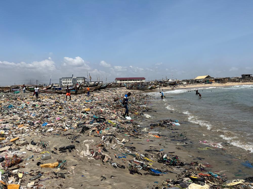 man walks on a polluted beach in tanzania