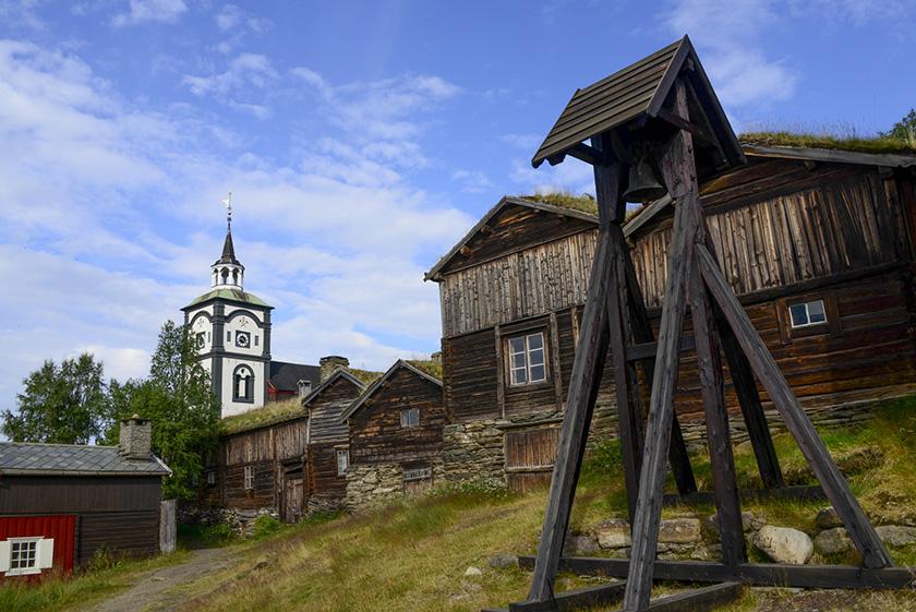 Photo showing Røros church and nearby old wooden buildings.