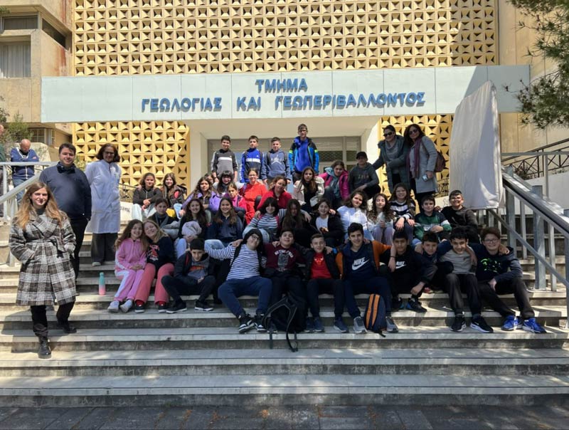 A group of students pose in front of a building.