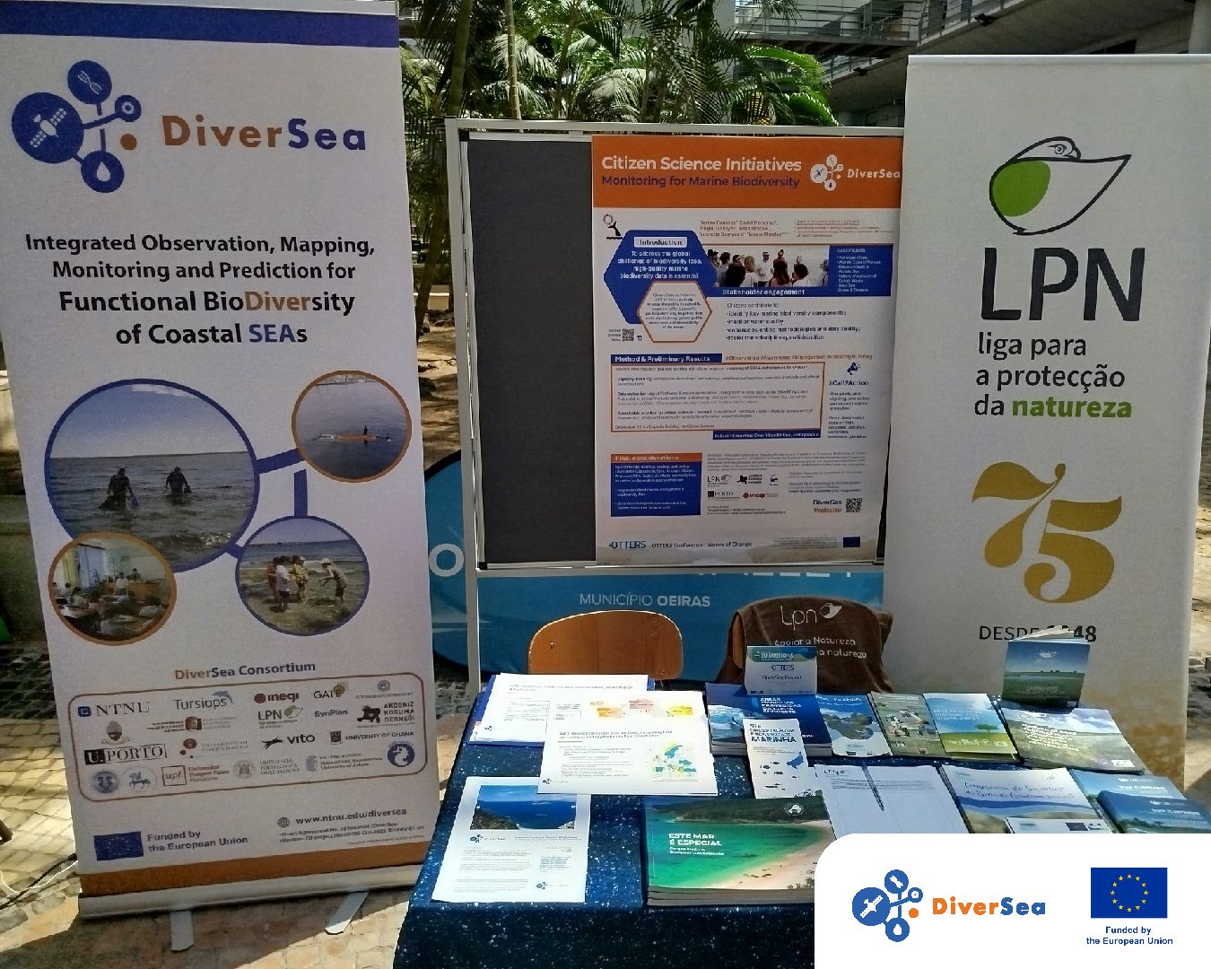Posters from DiverSea and LPN are displayed outdoors at a conference booth on a sunny day