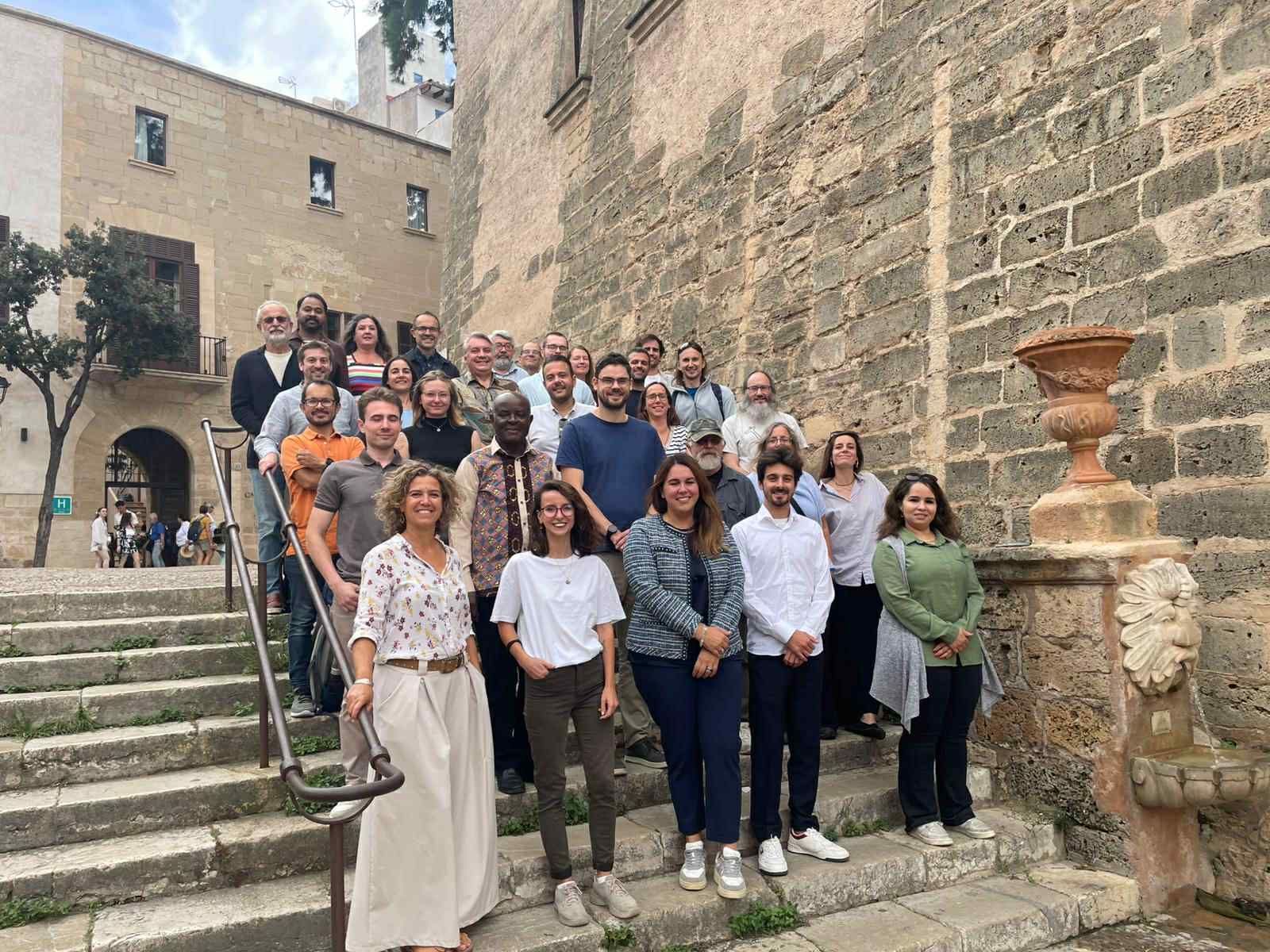 All attendees at the DiverSea 2025 Annual Meeting pose for a photo outside on stone steps near a scenic stone building