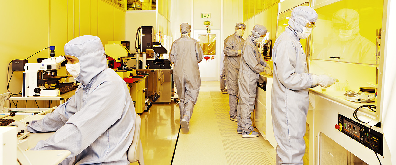 5 people in a laboratory dressed in safety equipment. Photo