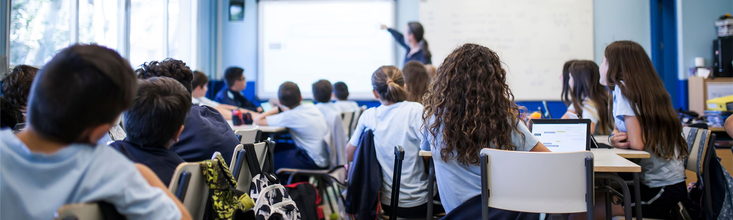 Photo of students in a classroom with a teacher in front.