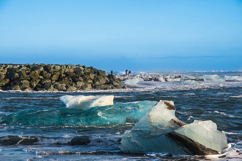 Arctic scenery with ice, sea and a small group of people in the distance
