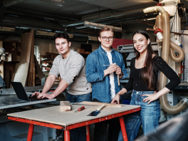Tre studenter i et verksted. 