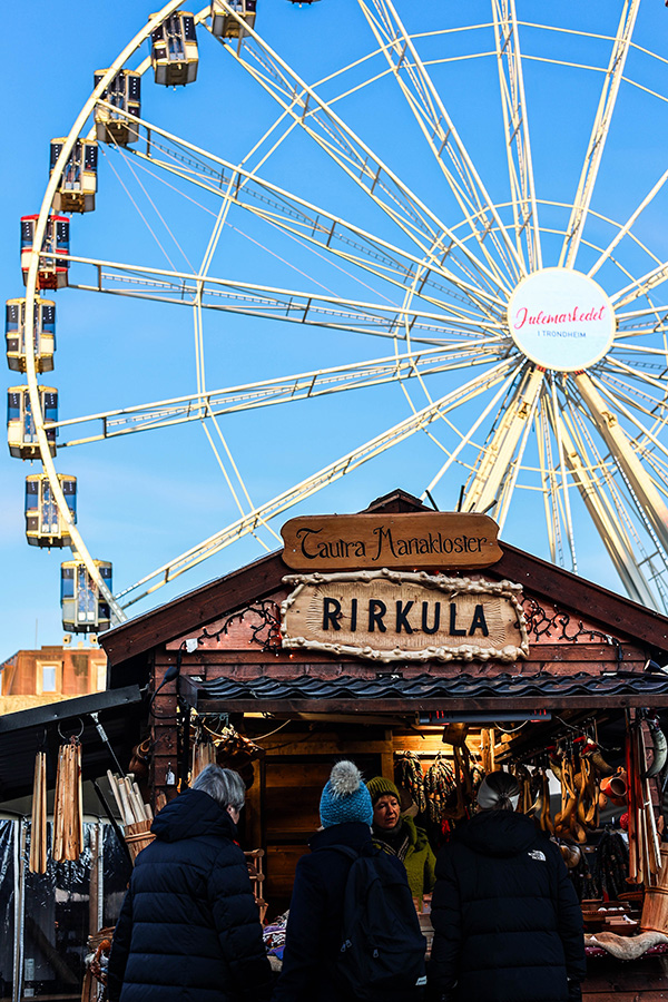Photp showing one of the stands at the Christmas market with the ferris wheel in the background