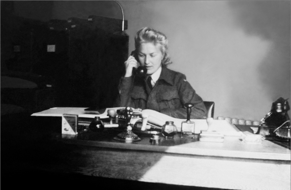 Liv Grannes sitting at her desk talking on the telephone. Photo