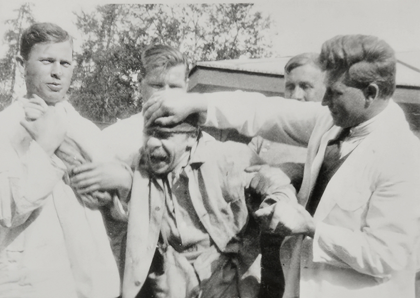 A patient being restrained by four health workers. photo