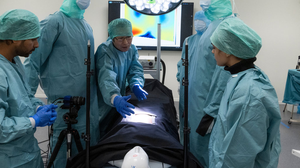 people and mannequins in surgical gowns in a lab. photo