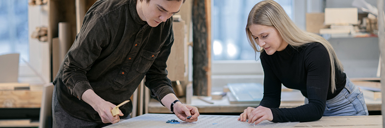 Two students working on a design board
