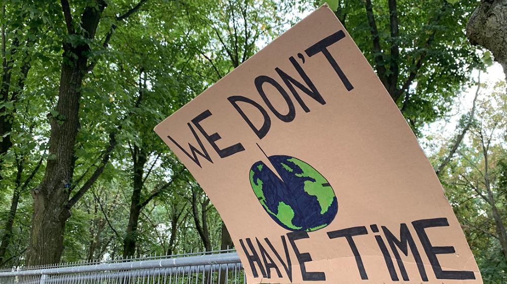 Photo of a cardboard sign saying "We do't have time"