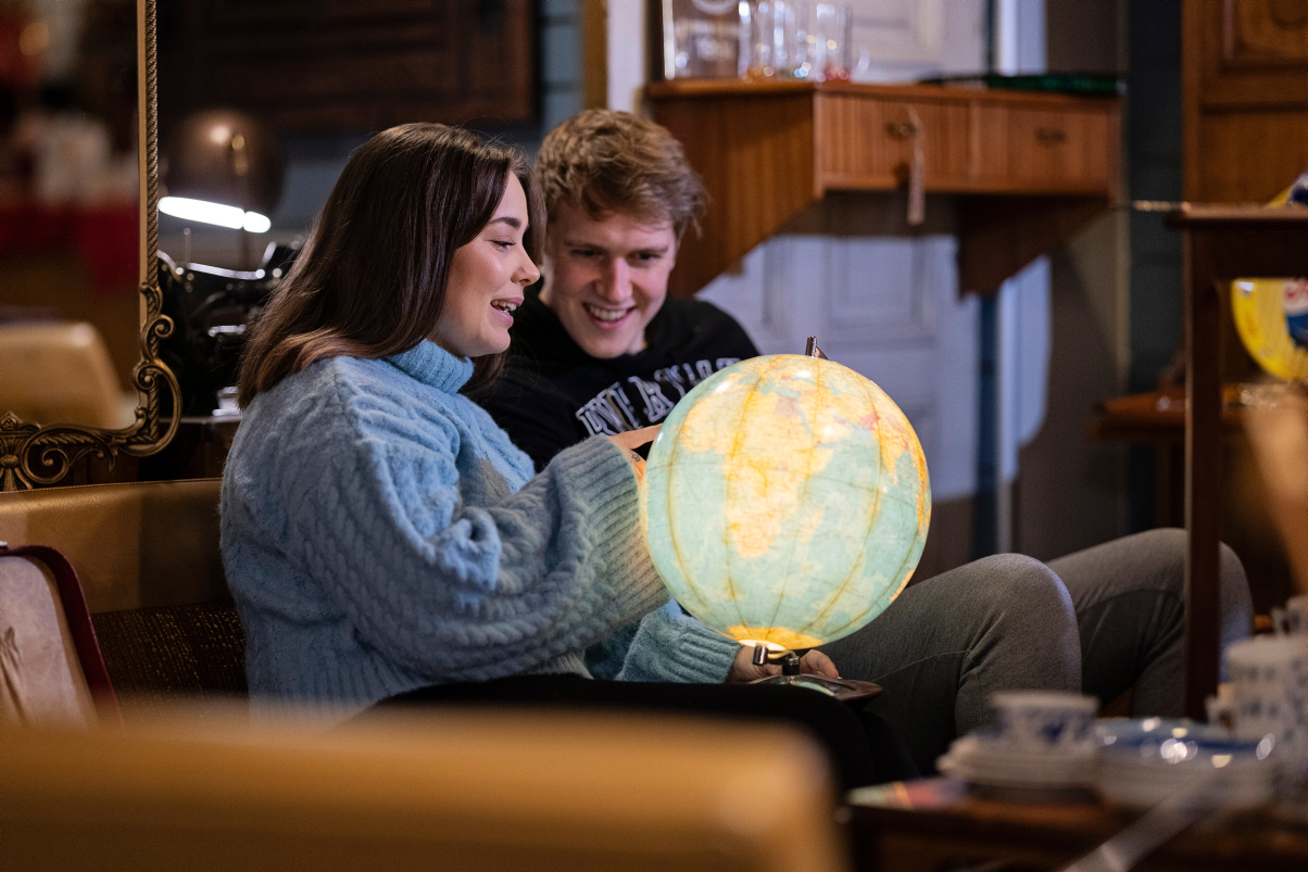 Two studens looking at a globe