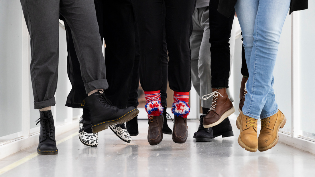 Feet with different kinds of footwar jumping in a hallway