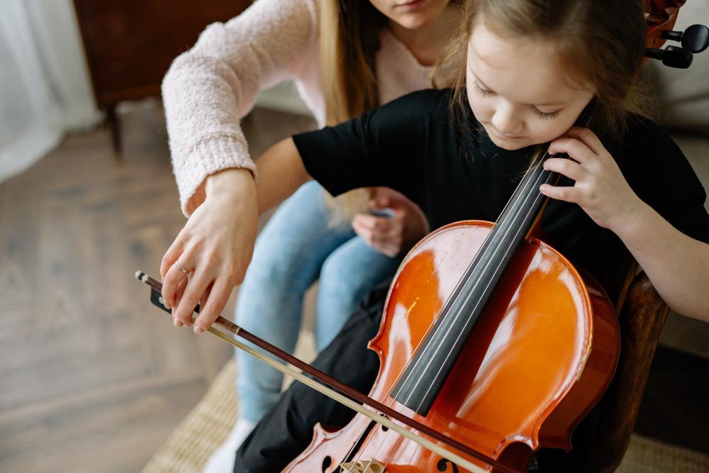 Music teacher with child playing the cello