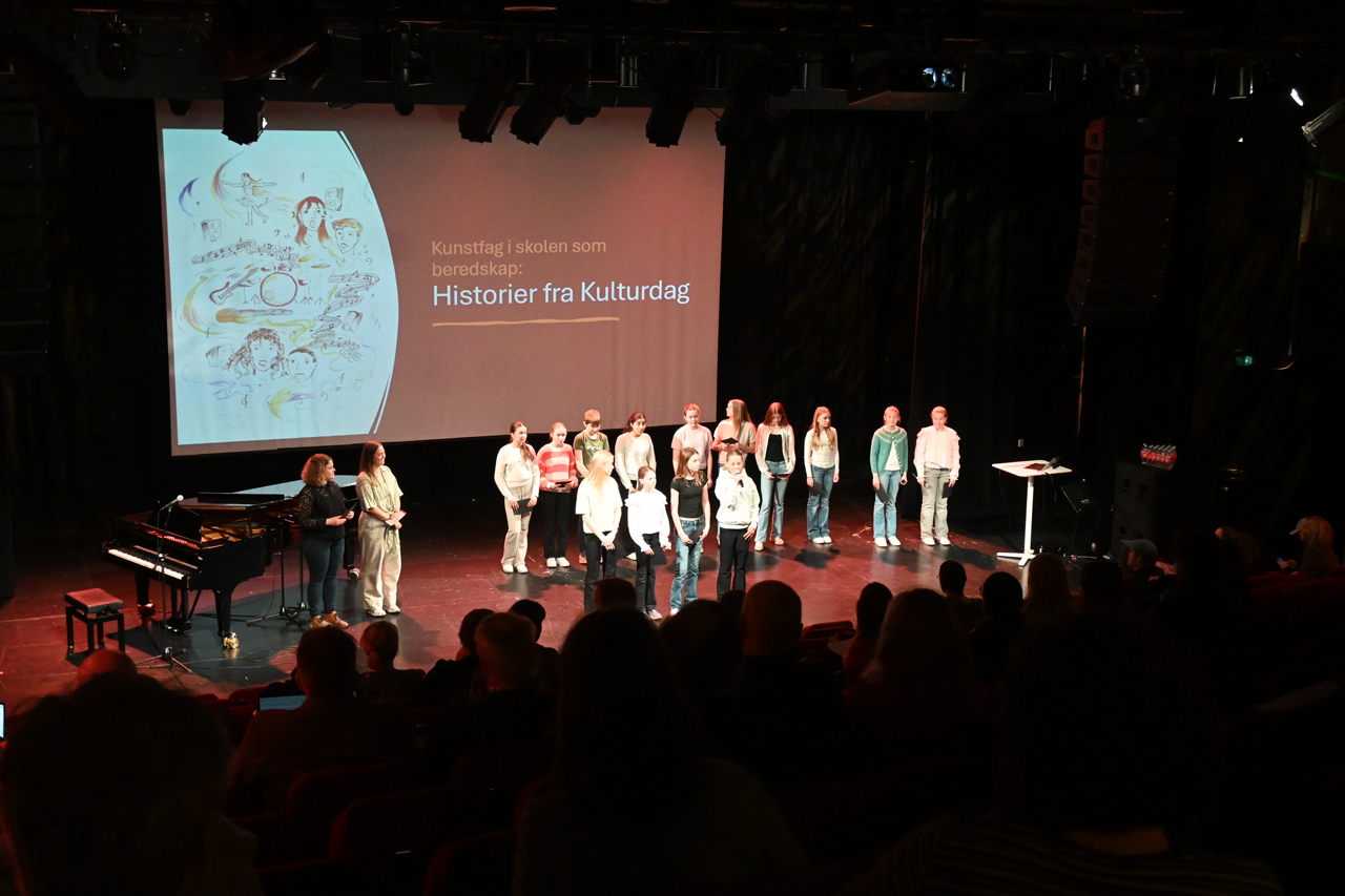 Presentation on stage during a conference with two adults and several students