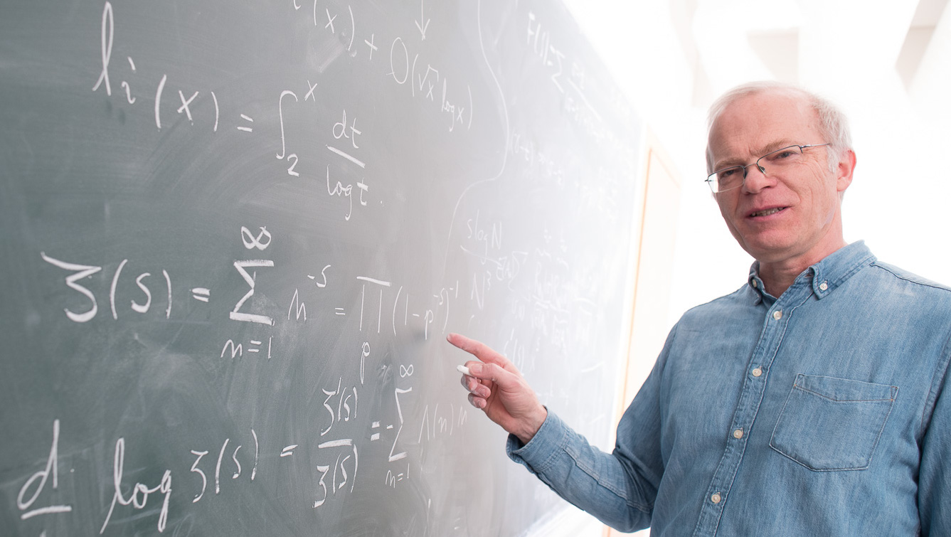 Mathematician Kristian Seip writing on a blackboard. Photo.