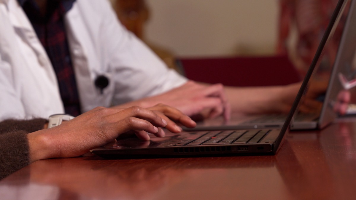 Hands writing on lap top.
