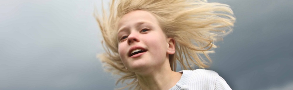Happy girl with wind in her ligt hair