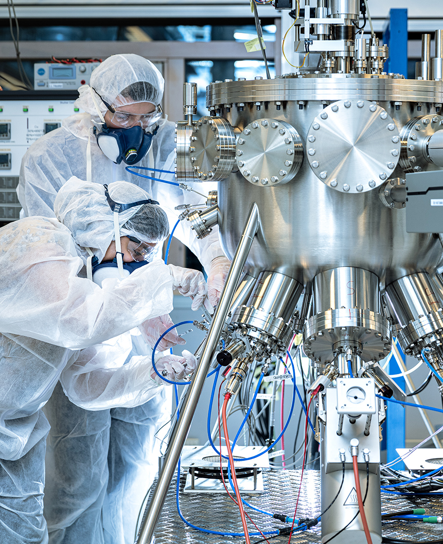 To forskere med skyddsklær som jobber sammen på lab