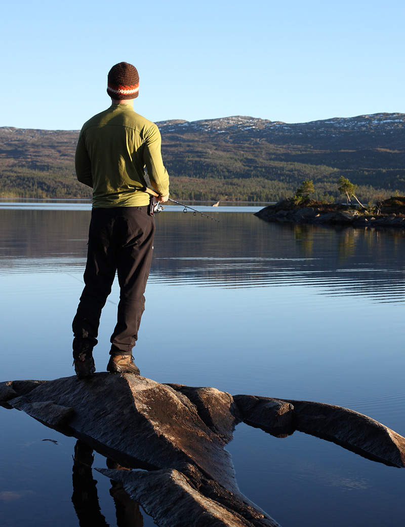 En mann som fisker i en stille sjø